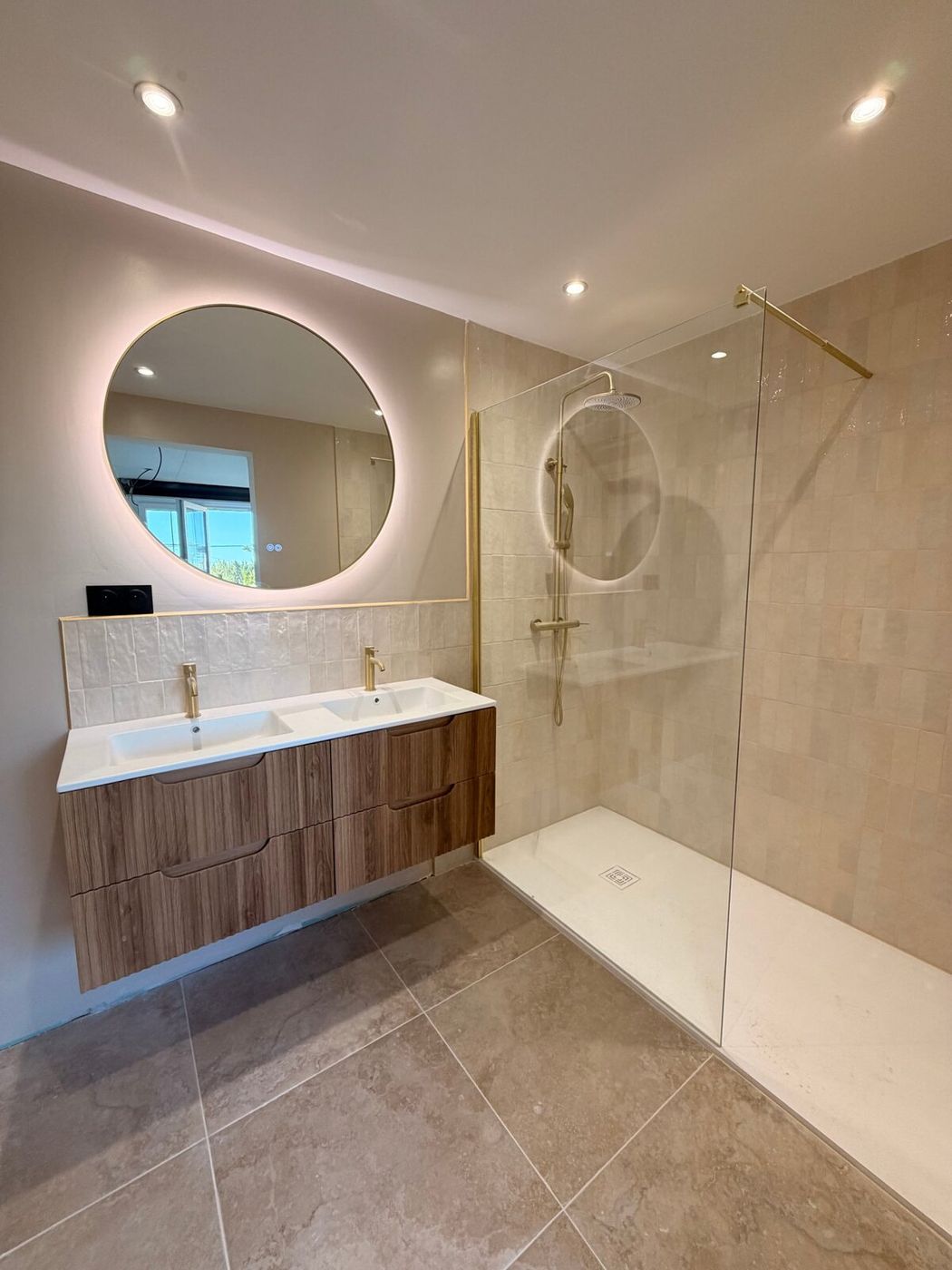 Salle de bain après rénovation : double vasque, douche à l’italienne et carrelage zellige